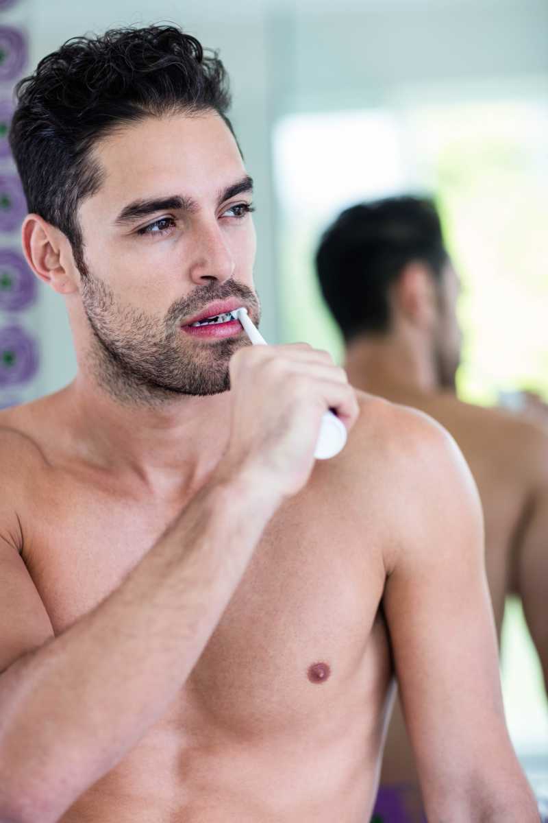 光着上身刷牙的男人