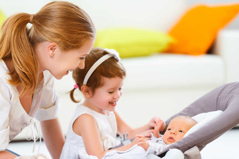 母亲和女儿与新生婴儿