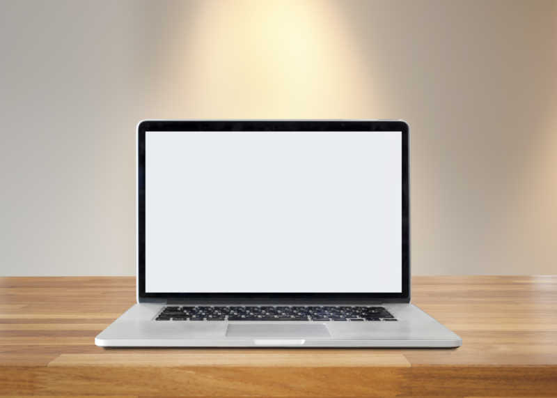 室内光照的木桌上的空白屏幕笔记本电脑
