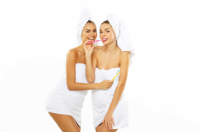 两个漂亮女孩沐浴后刷牙齿