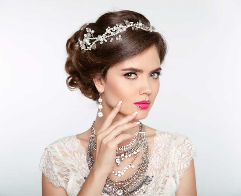 白色背景下带着珠宝的奢华的新娘