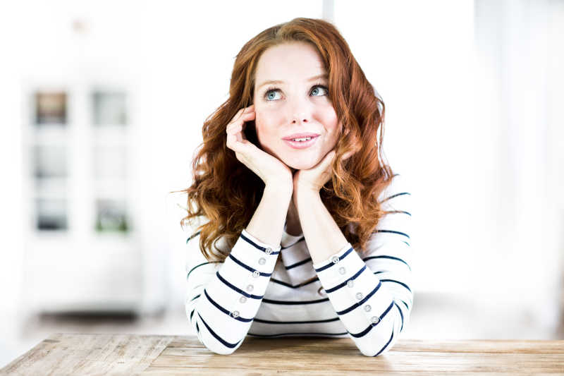 趴在木桌旁边的充满幻想的美女