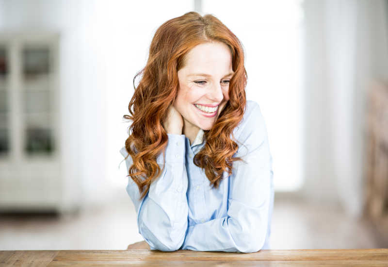 趴在木桌上的微笑的金发女人