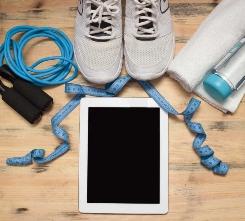 木桌上的健身工具和卷尺以及日记本
