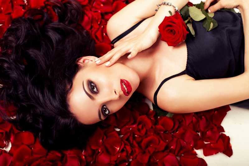 躺在玫瑰花瓣上的年轻美女