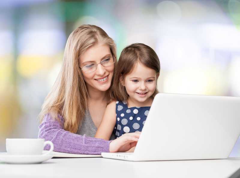 温馨的背景下母女一起使用笔记本电脑