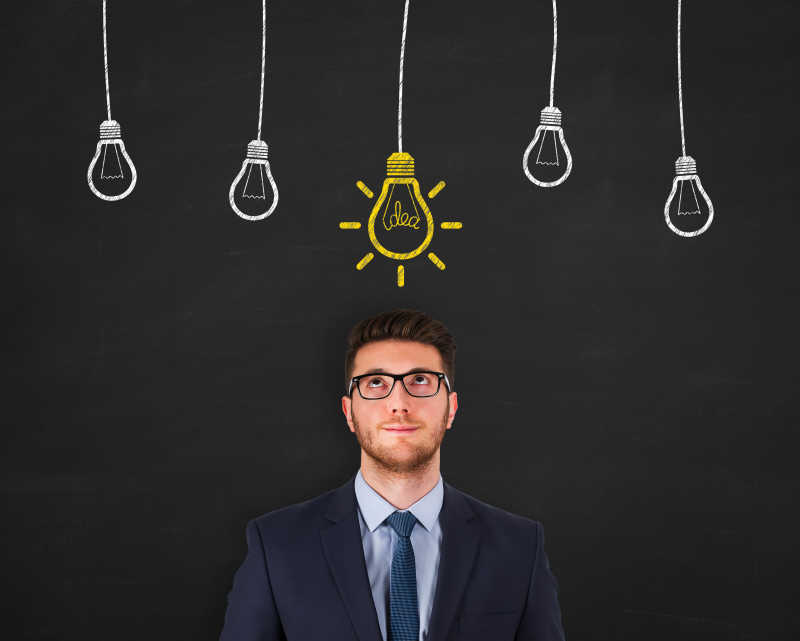 商人站在画着灯泡的黑板前面