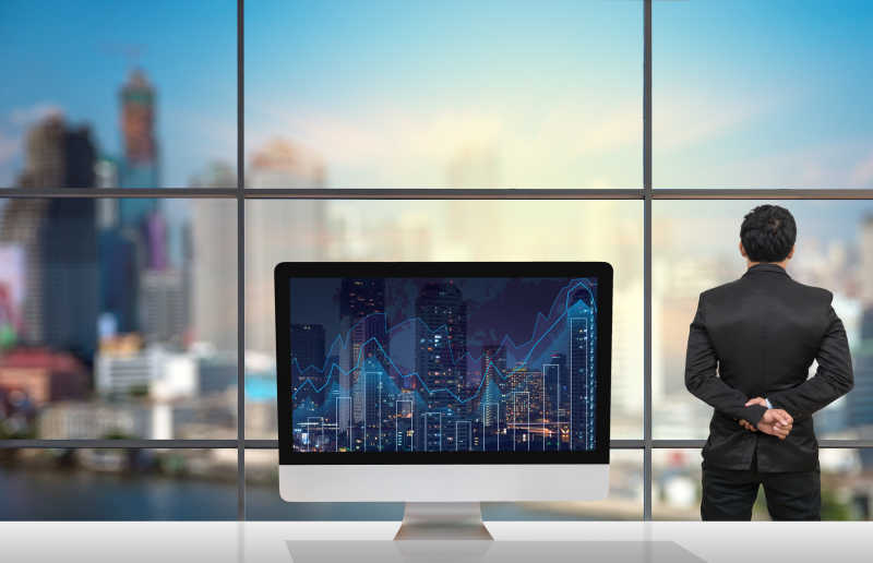 电脑在会议桌上商人从窗户看外面的景色