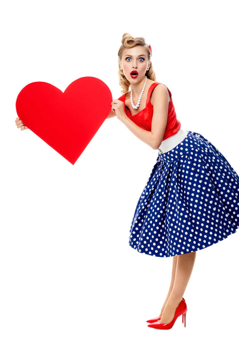 白色背景下一个美丽的妙龄女郎手上拿着一颗红色的心