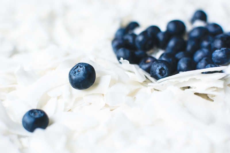 散落的白色椰蓉上的蓝莓果