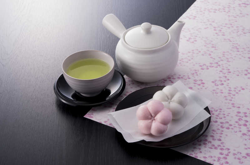 黑色桌花布上的一碗绿色茶