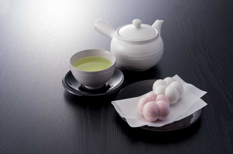 黑色桌上的放置的茶壶和一杯绿茶水