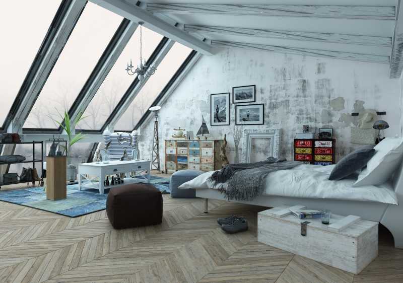 现代时髦的铺着木地板具有斜窗的阁楼卧室
