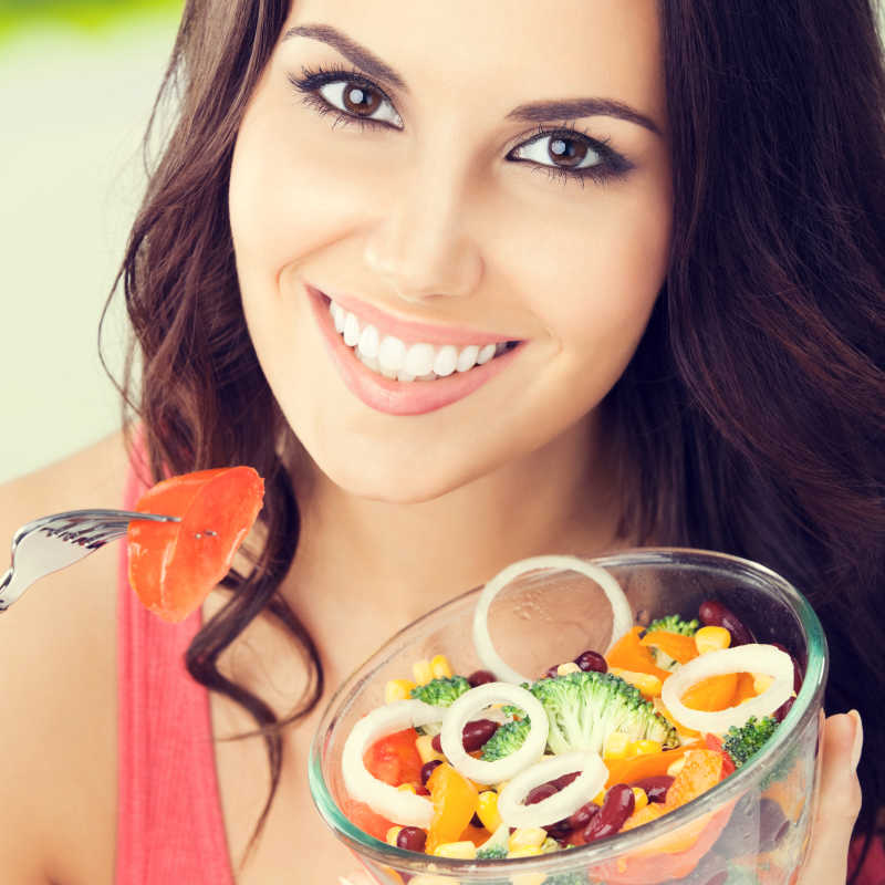 户外的快乐女人准备吃沙拉