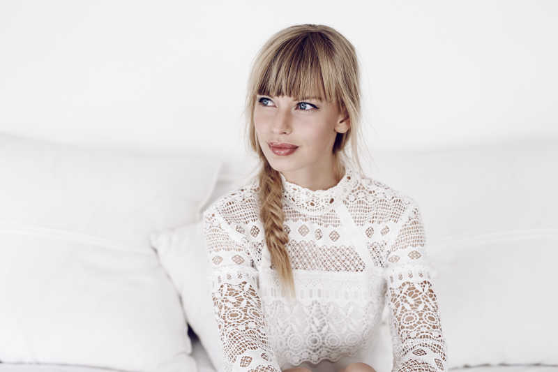 白色沙发上若有所思的年轻女子