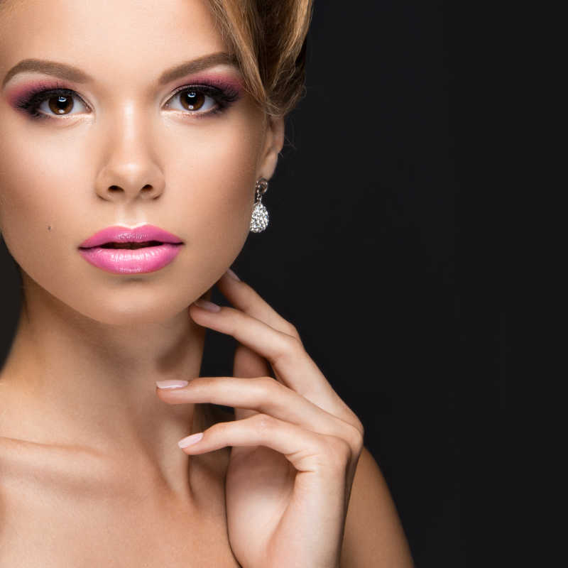 黑色背景下画着彩妆的金发美女新娘