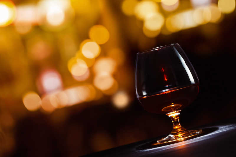 灯光背景下高脚杯里的白兰地