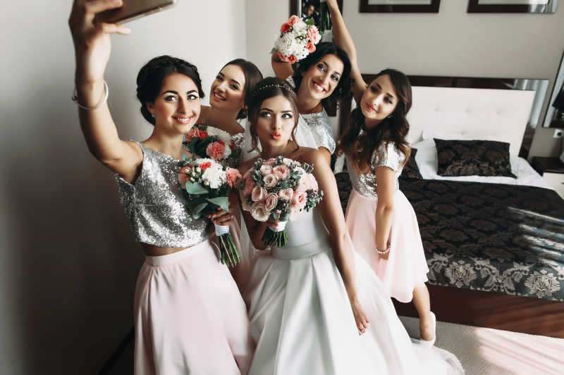 新娘和伴娘用手机拍合照