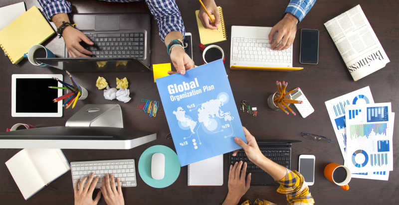 在办公桌上工作的商人交换笔记本