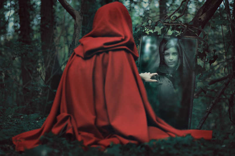 魔镜前面穿着红斗篷神秘女人