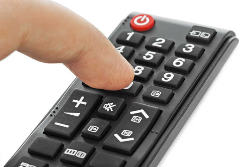 在白色背景下使用遥控器的手