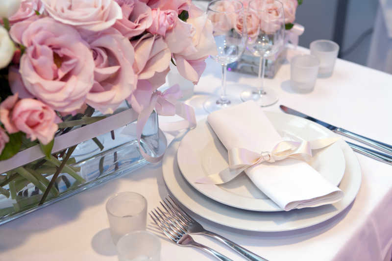 白色餐桌上的餐具和装饰花朵