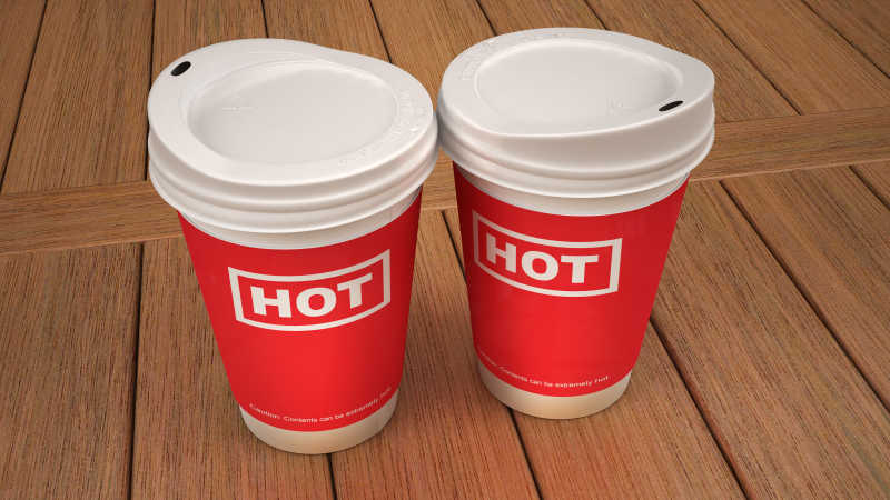 木桌上的两个红色热饮杯