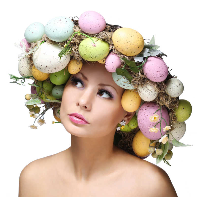 粉色背景下头戴复活节彩蛋装饰向上看的女人