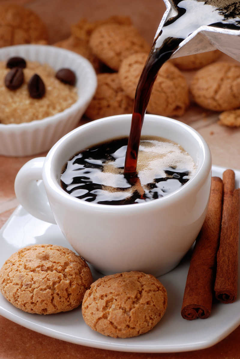 倒杯热咖啡与甜点饼干