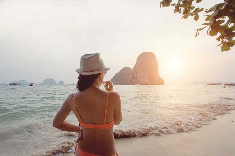 日落下海边穿着比基尼的美女背影