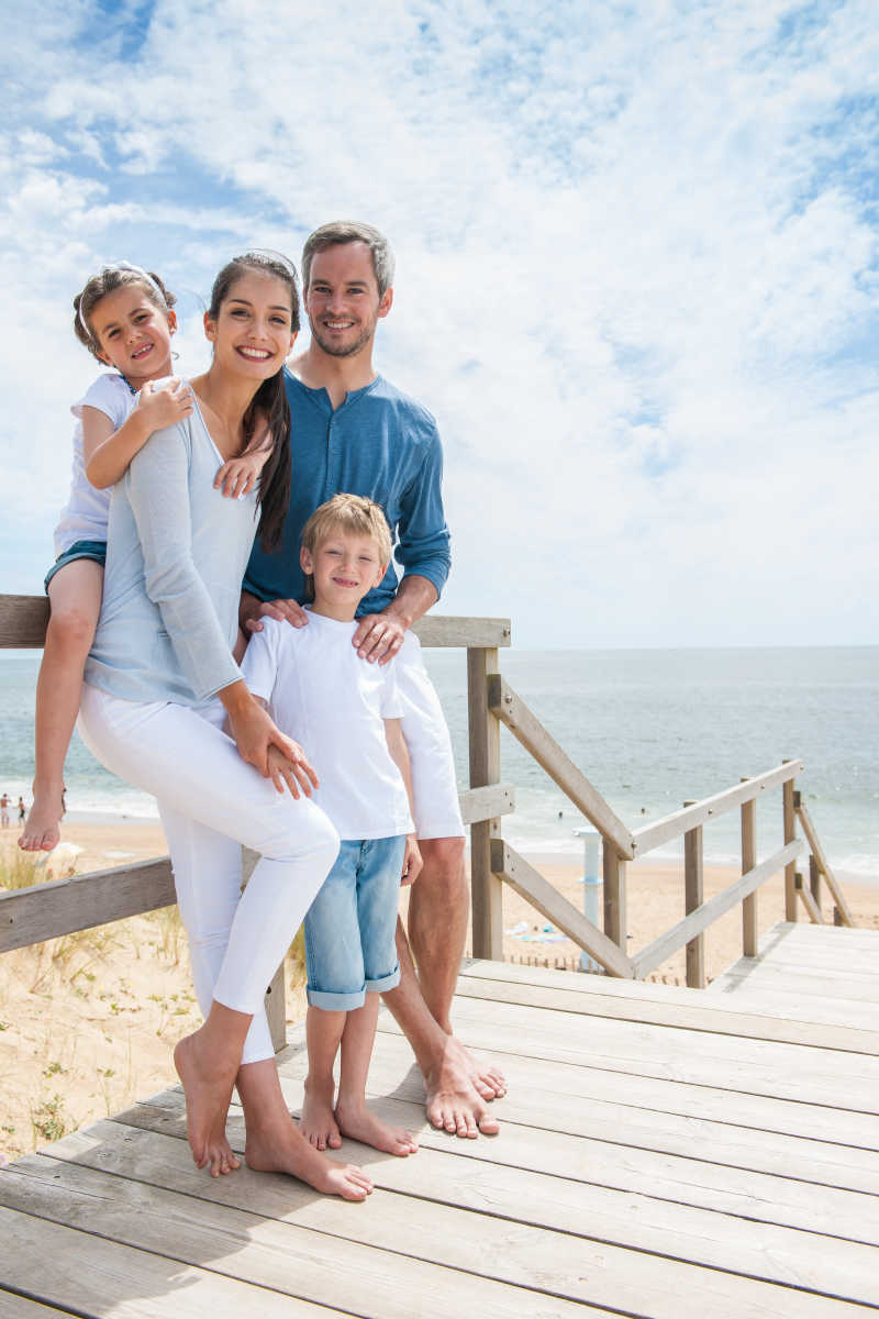 海边站在木桥上的幸福家庭