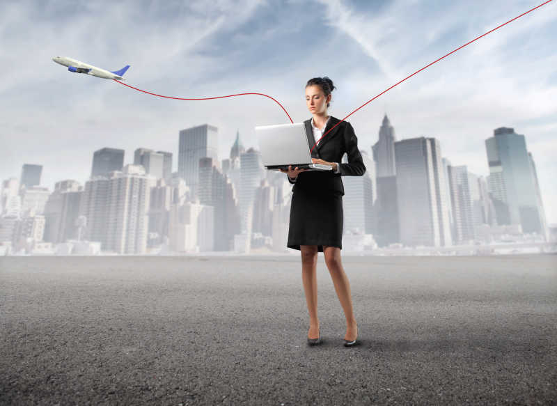 蓝天下的商人拿着笔记本电脑