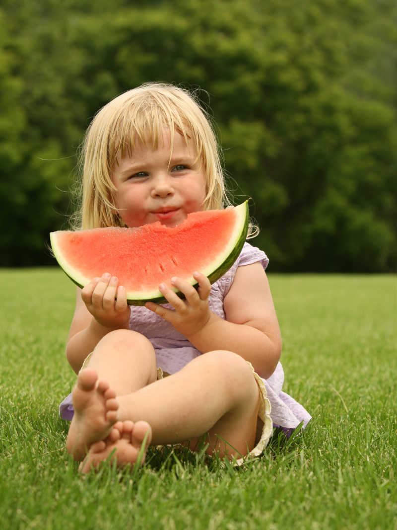 草丛上啃西瓜的女孩