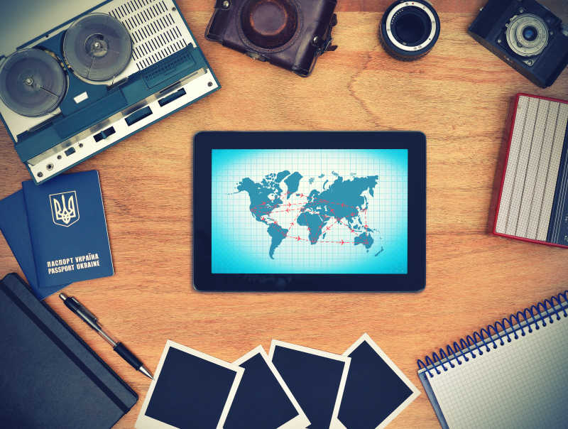 蓝色屏幕上带有空中旅行方案的触摸屏在桌子上