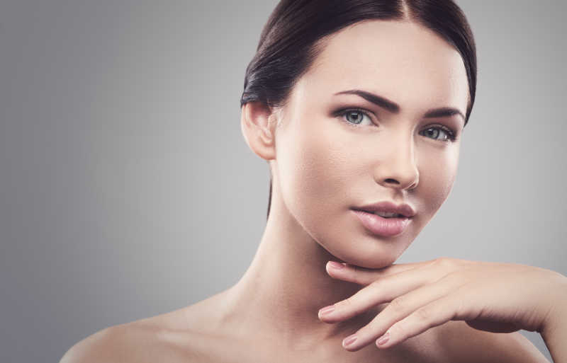 灰色背景上的年轻女孩肖像