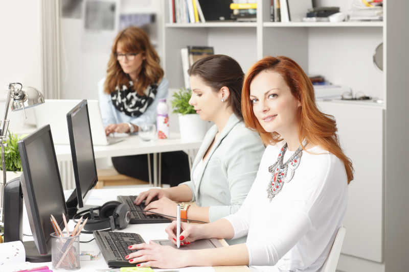 与办公室同事合作的现代女性平面设计师