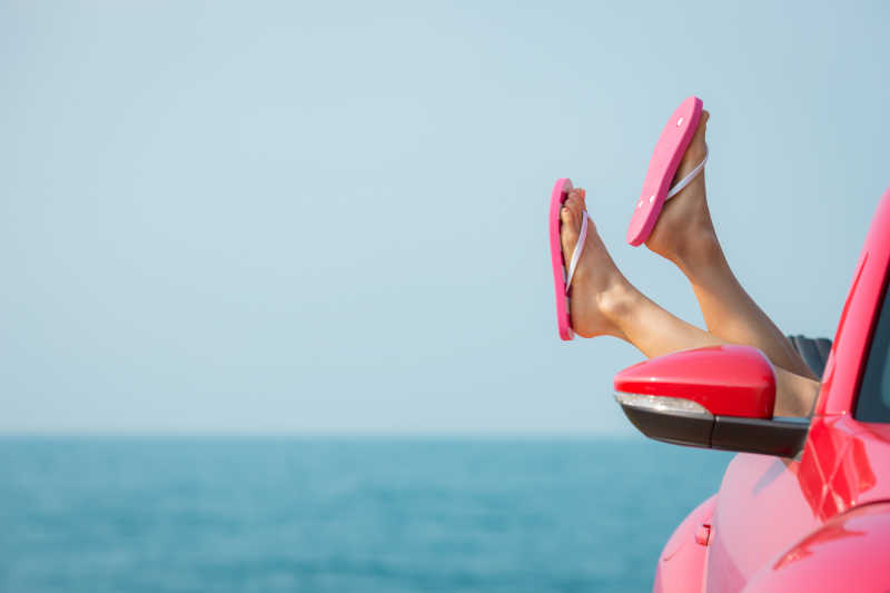 在海滩上放松双腿的年轻美女