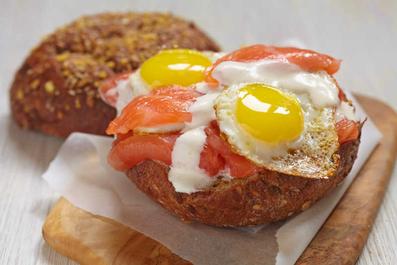 菜板上美味的三文鱼三明治配煎鸡蛋和蛋黄酱