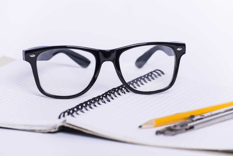 白色背景下的眼镜和笔及笔记本
