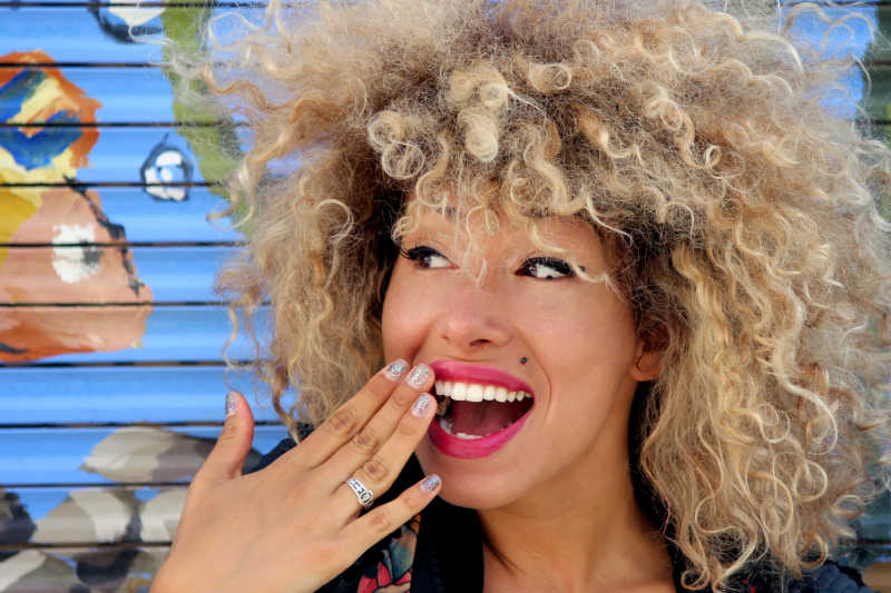 捂嘴大小的非洲金发妇女