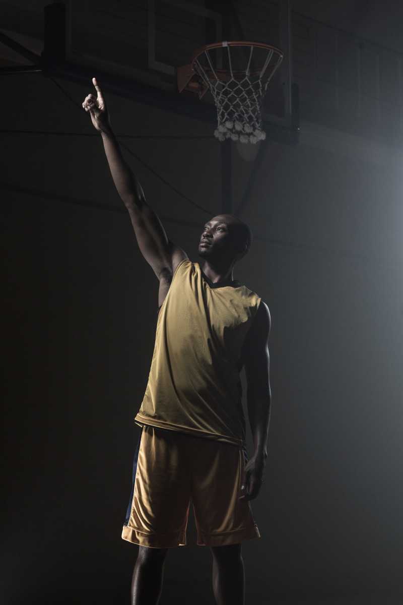 篮网下的篮球运动员用手指指着前方