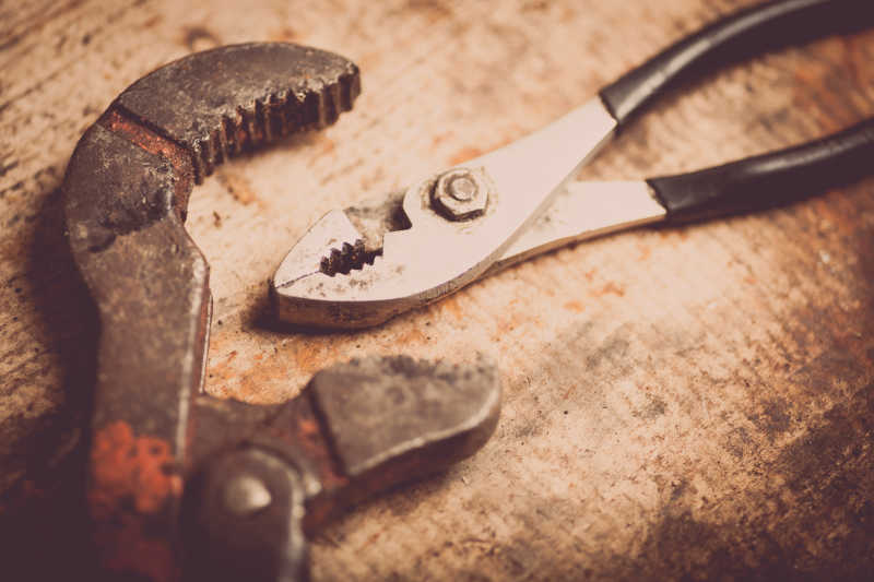 木板上的可调式扳手和钳子