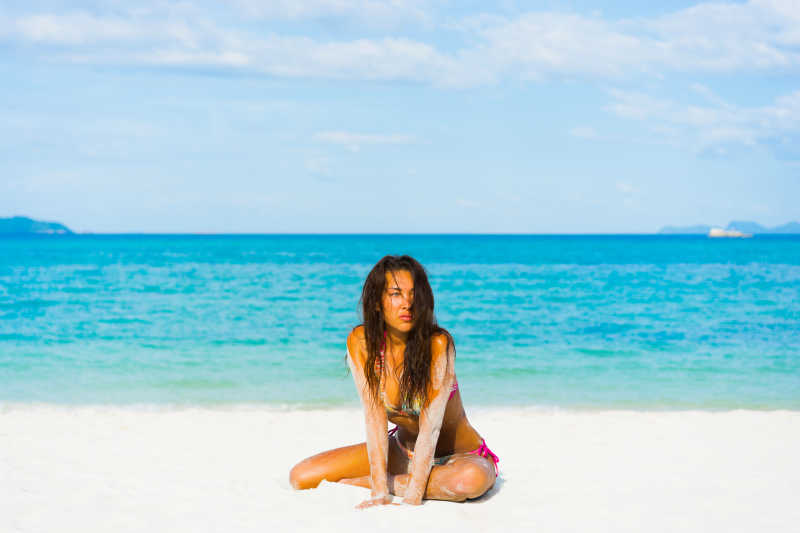 蓝色大海边白色沙滩上穿比基尼的美女