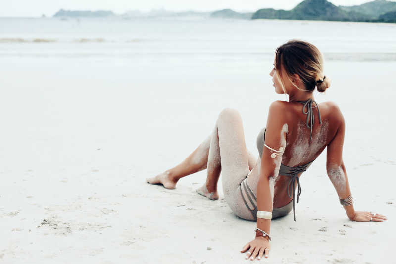 白色海滩上穿着灰色波希米亚风格比基尼的美女