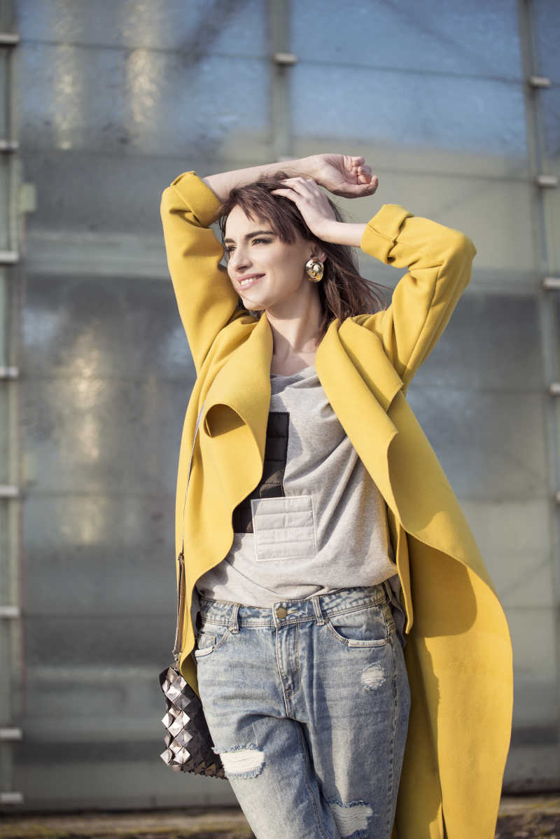 穿着黄山外套牛仔裤的时尚女子