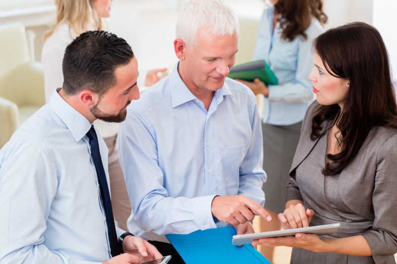 办公室里在看平板讨论的商务人士