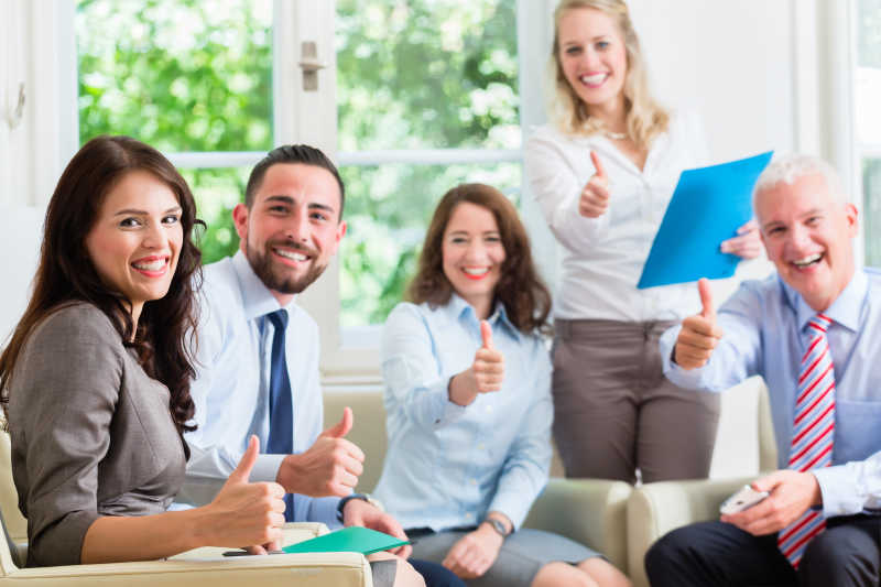 办公室男女正在竖大拇指表示成功