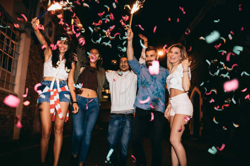一群在户外聚会扔五彩纸屑的年轻人