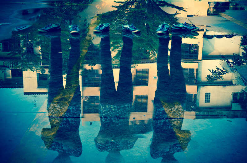 蓝色背景下三人和雨水路面双重曝光