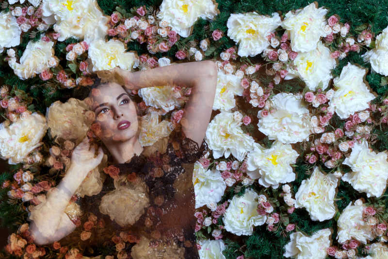 女人和草地上的白色花朵的双重曝光